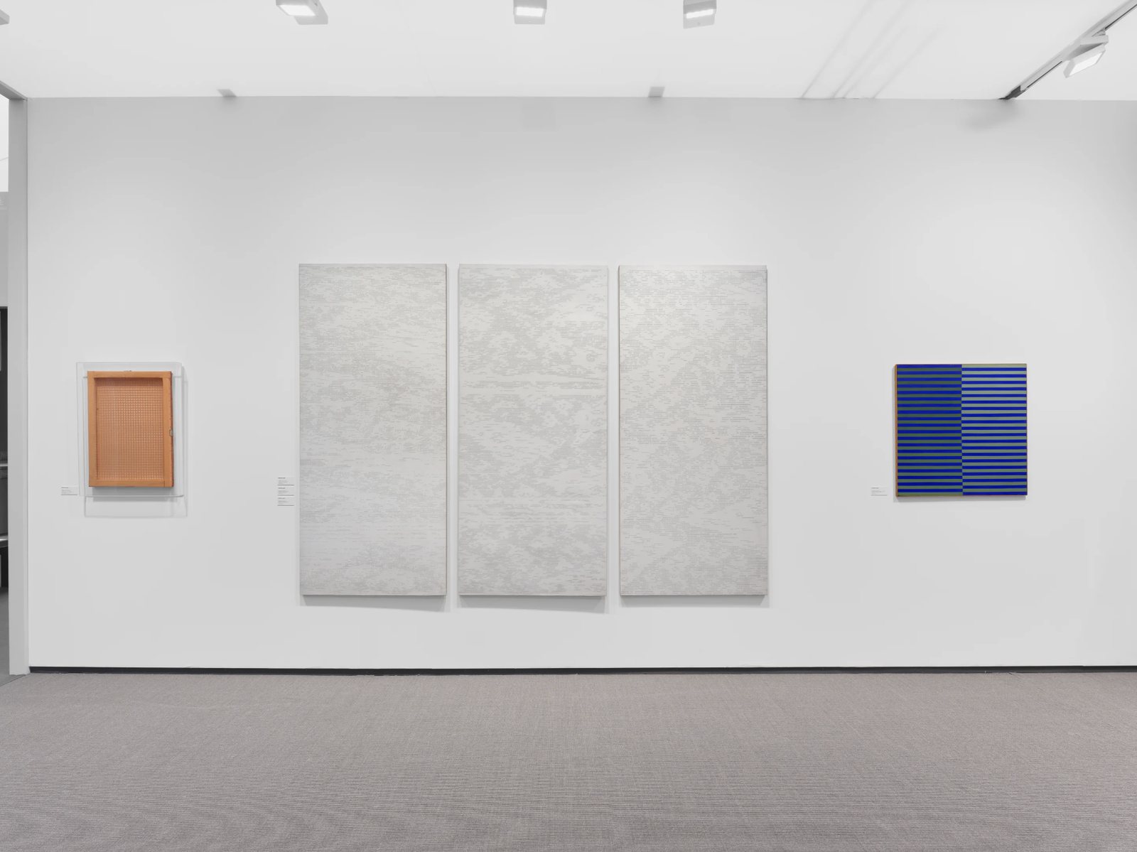 Installation view of Marlborough's booth at Frieze Masters 2023: a white triptych between two smaller works
